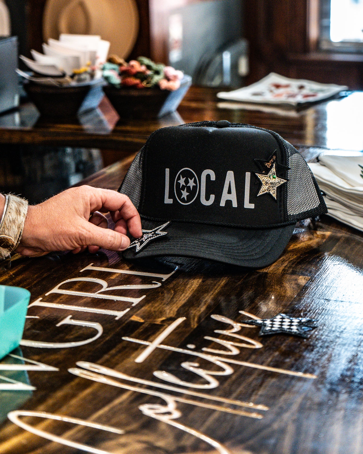 Black cap with 'LOCAL' text on a wooden table